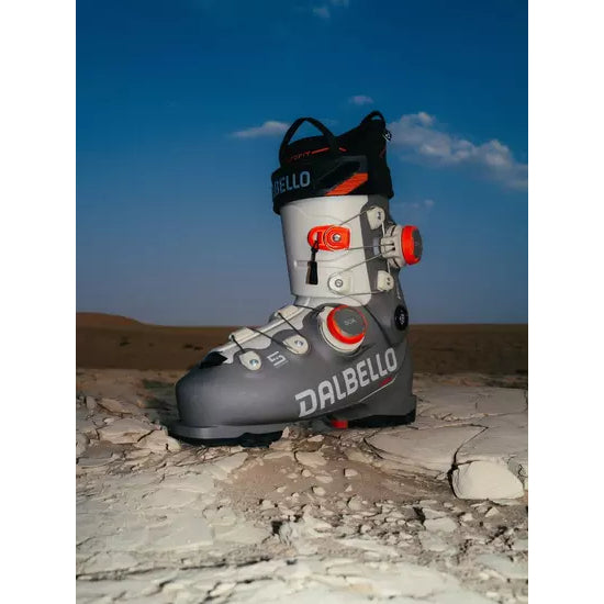 A Dalbello Veloce Space boot in a grey and white colourway standing on desert rock